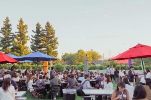 Guests enjoying food and drinks outside at the Plug and Play venue